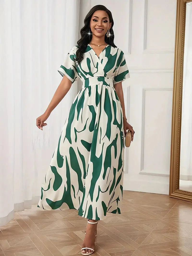 Woman wearing a green and white patterned dress in a room with white walls and wooden flooring.