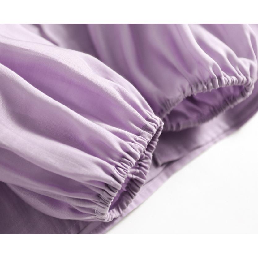 A close-up of lavender purple fabric with gathered elastic cuffs, showing the texture and folds of the material against a white background.