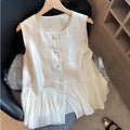 White sleeveless top on a hanger with a blurred background