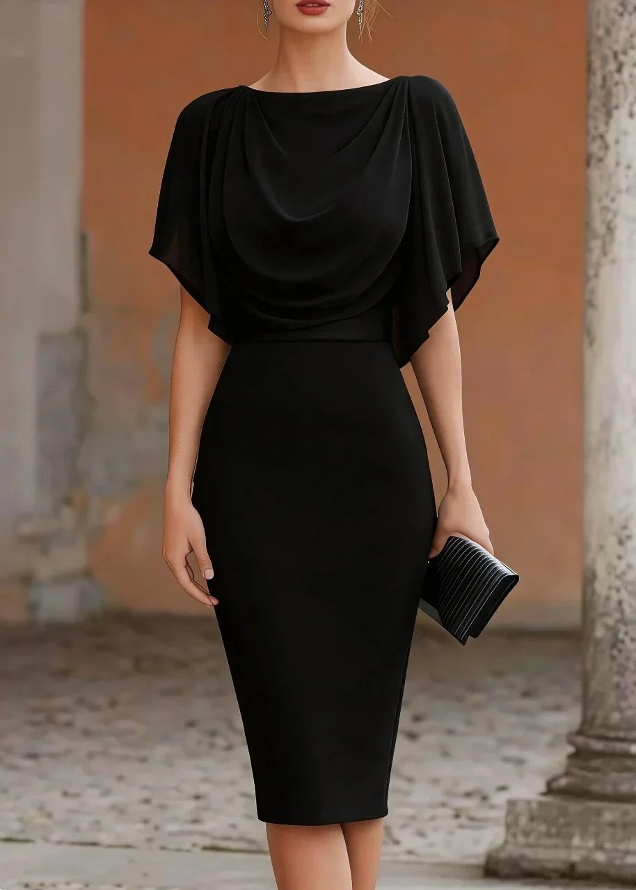 Woman wearing a black dress holding a clutch in an outdoor setting